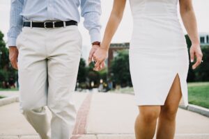 Imagem de um casal de mãos dadas caminhando em um parque