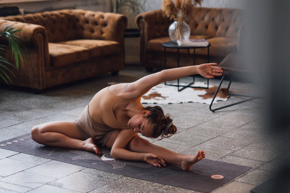 Mulher fazendo yoga na sala de estar